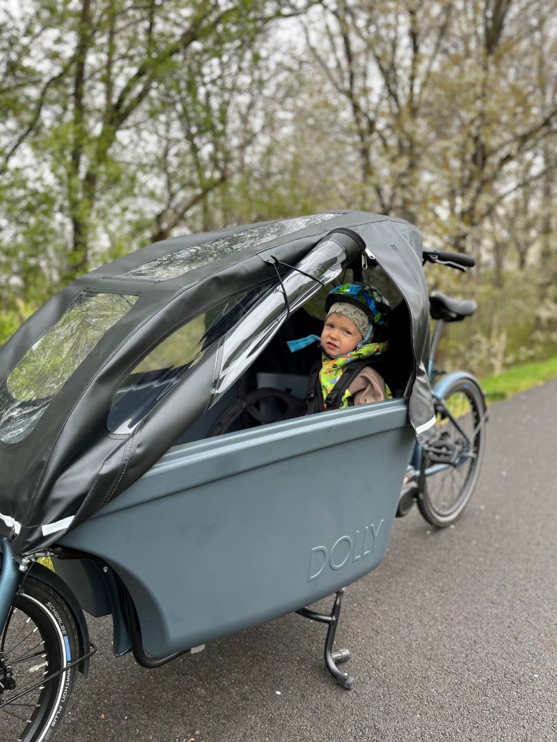 Kid in a cargobike with roof